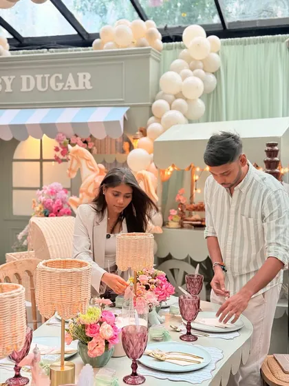 My team and I meticulously arranging every detail on the tablescape for the Parisian baby shower, ensuring every element is perfect.