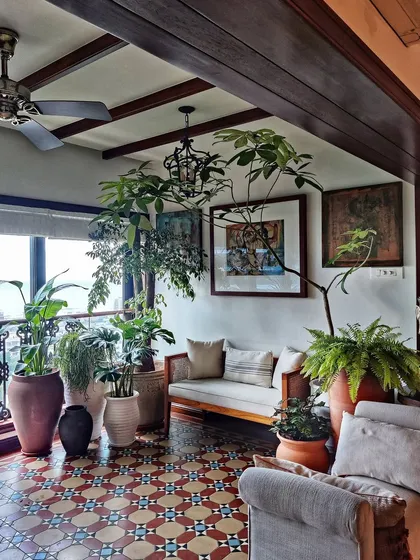 This cozy corner from a client's home is a perfect example of jungalow style. A few years after our initial setup, the plants have grown beautifully, creating a lush, layered look with terracotta pots and vintage tiles.