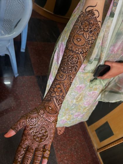 A single-arm view of a beautiful bridal design. The patterns are a mix of floral and traditional Indian motifs.