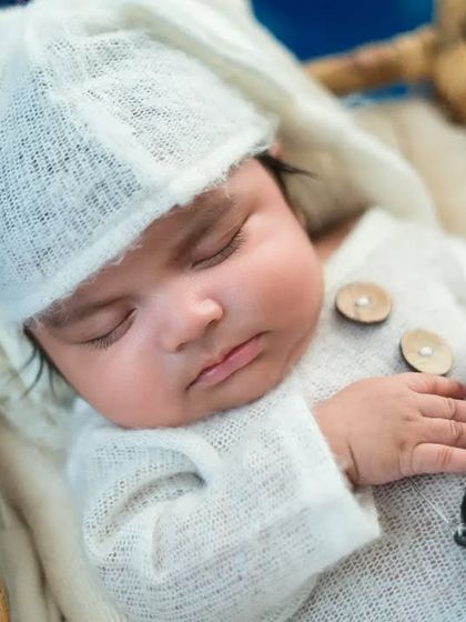 A star is born. This newborn boy looks so peaceful in his white outfit, sleeping in a basket with a tiny lantern.