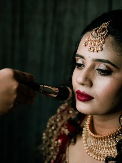 A behind-the-scenes look at the bride getting her makeup touched up, highlighting the preparation for the big event.