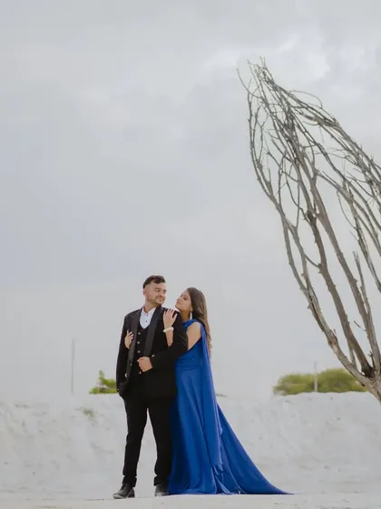 A wide shot that showcases the stark, beautiful landscape. The lone tree adds a point of interest and a touch of raw nature to this modern pre-wedding photo.