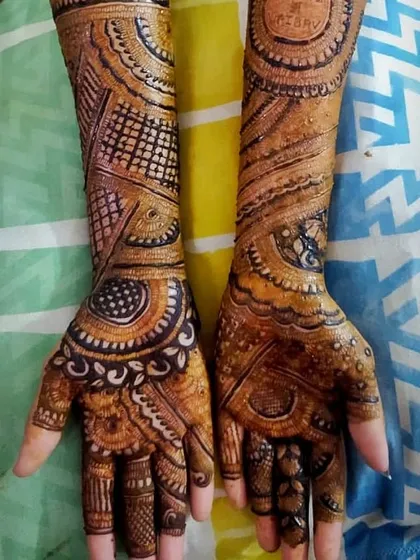The rich, dark stain of a full-hand mehandi design. The pattern is a beautiful mix of circular mandalas, leaf motifs, and fine line fillers.