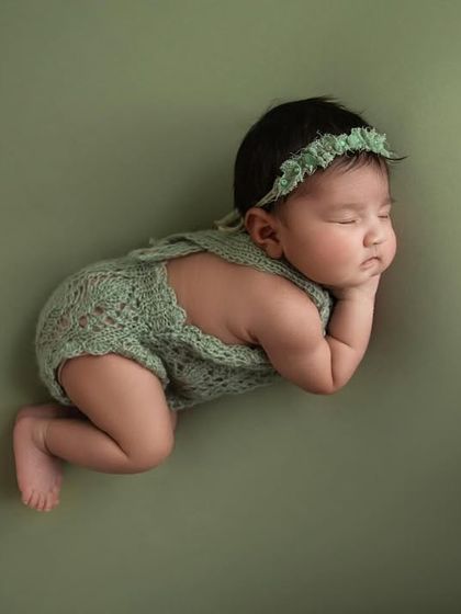 An artistic, wide angle shot of a baby in a side pose, creating a feeling of peace and solitude.