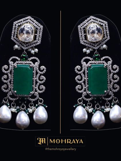 A pair of stunning statement earrings featuring large emeralds, uncut polki, and pearl drops. You can rent just the earrings to elevate your look.