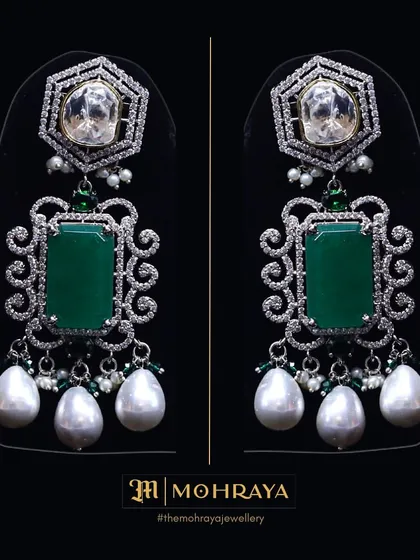 A pair of stunning statement earrings featuring large emeralds, uncut polki, and pearl drops. You can rent just the earrings to elevate your look.