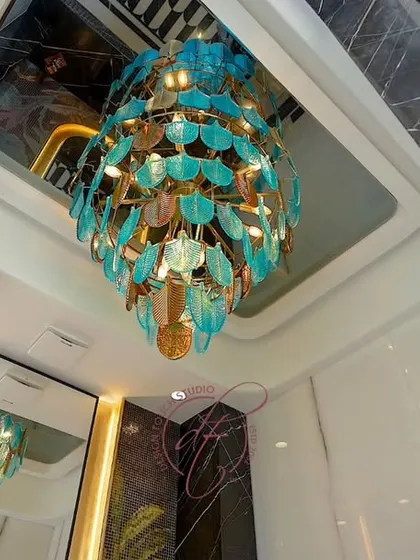 A worm's-eye view of the magnificent turquoise chandelier, which serves as the centerpiece of the powder room. The reflection in the ceiling mirror enhances its dramatic effect.