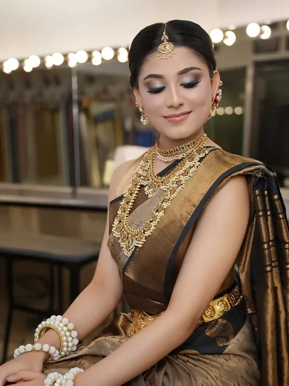 A full view of the South Indian bridal look, showcasing the elegant saree drape, the gold waist belt (vaddanam), and the serene makeup.