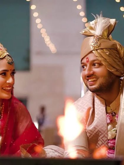 A candid moment of a couple smiling at each other during their pheras around the sacred fire.