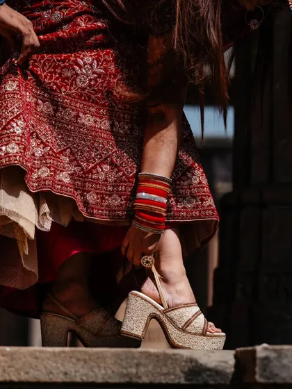 It's all in the details. This shot focuses on the bride's traditional bangles and ornate footwear, capturing the rich cultural elements of a heritage-themed photoshoot.