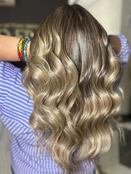 A beautifully blended balayage with cool, ashy tones. The seamless transition from the natural root color to the lighter ends is our specialty.