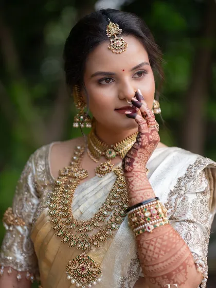 A classic portrait in a white and gold Kanjivaram, with traditional gold jewellery and kohl-defined eyes.