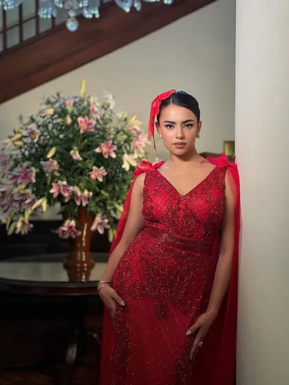 A beautiful portrait against a floral backdrop. The contrast between the bold red and the soft flowers is stunning.
