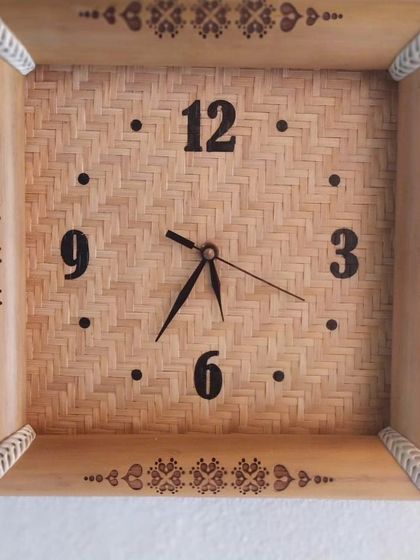 This unique wall clock is framed with natural bamboo and features a woven bamboo face. The intricate pyrography designs on the frame add an artistic, handcrafted touch, making it a functional piece of wall art.