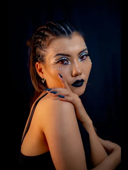 A profile view of the catwalk look, showing the intricate glitter pattern and the edgy hairstyle.