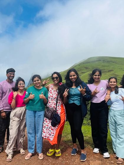 Thumbs up and peace signs from a happy group on a sunny day in the Chikmagalur hills.