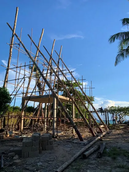 The timber scaffolding for the new spa rises against the blue sky. This temporary structure is a piece of craftsmanship in itself, built by local workers to enable the construction of the permanent building.