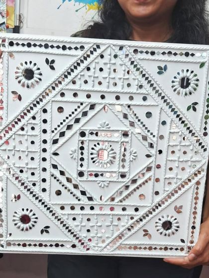 A close up of a finished Lippan art piece, highlighting the geometric patterns and shimmering mirror work. Our students learn to create these intricate designs from scratch.