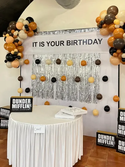 The cake table, ready for the celebration. Set against the "IT IS YOUR BIRTHDAY" backdrop, this simple, skirted table was the designated spot for the main event, perfectly in character with the theme.