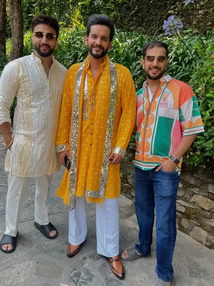 A vibrant Haldi ceremony look, featuring a custom yellow kurta with silver mirror work detailing. We create themed outfits that bring the whole family's style together for every wedding function.