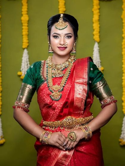 The combination of a red saree and green jewellery is a classic. This model looks stunning in this complete bridal set.