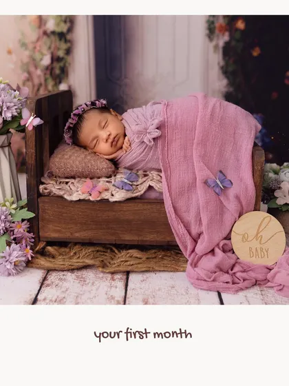 A sleeping baby in a tiny wooden bed, surrounded by a dreamy purple and butterfly theme. This image captures the peacefulness of your baby's first month.