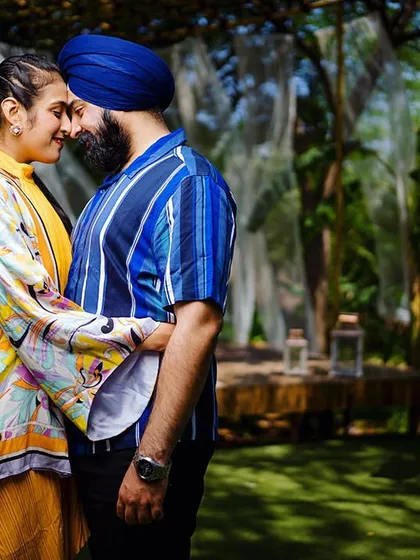 Maha and Ashween share an intimate moment at our Bali-themed set. The vibrant colors of their outfits pop against the lush green background.