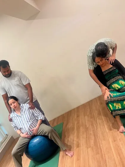 Here you can see couples in our Bangalore studio practicing partner-supported labor positions. We focus on hands-on techniques like using a birth ball for comfort and having your partner apply counter-pressure to ease back labor, ensuring you both feel prepared and connected.