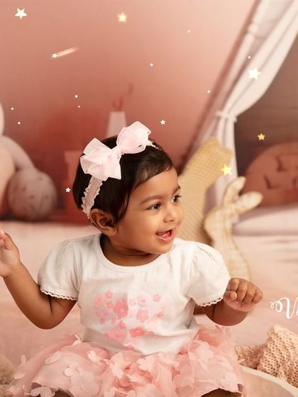 A happy dance in a pink wonderland. This shot captures the toddler's playful energy and movement during her fun, themed studio photoshoot.