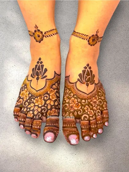 A stunning bridal foot mehendi design. The toes are covered in a dense floral pattern, with a lotus motif on top and a simple floral anklet to complete the look.