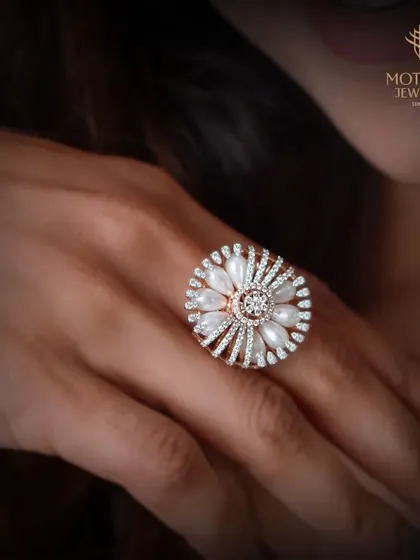 A floral-inspired ring featuring lustrous pearl petals and a diamond center, set in warm rose gold for a romantic and sophisticated look.