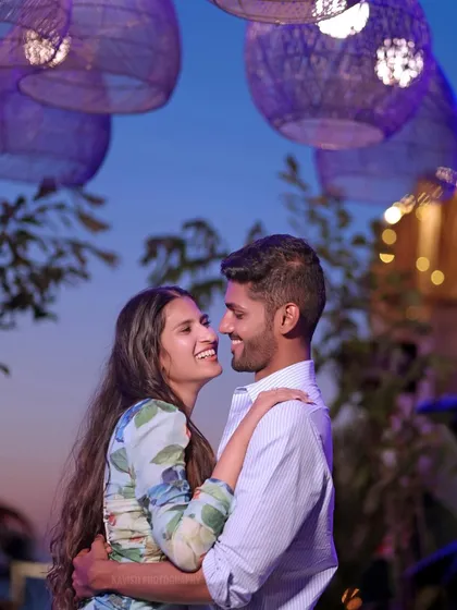A candid shot of a couple sharing a laugh during their evening pre-wedding session, filled with genuine joy.