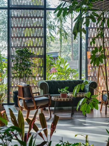 A patterned terracotta screen provides privacy and filters sunlight, casting intricate shadows across the room. This element of biophilic and culturally-inspired design adds texture and artistry while connecting the interior to the outdoors.