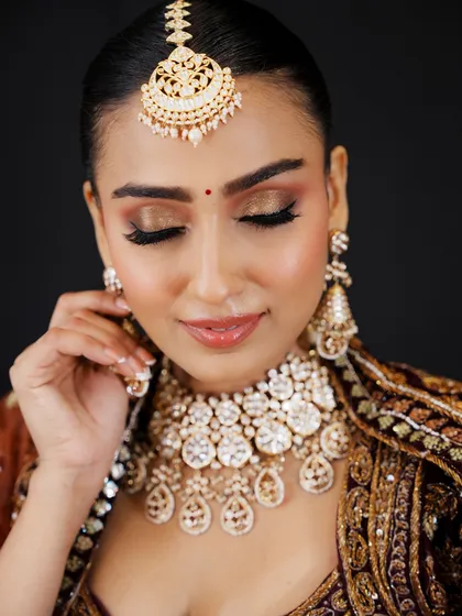 A close-up on the eyes shows the precision of the eyeliner and the shimmer on the lid. I emphasize detail-oriented work to ensure every element of the makeup is perfect.