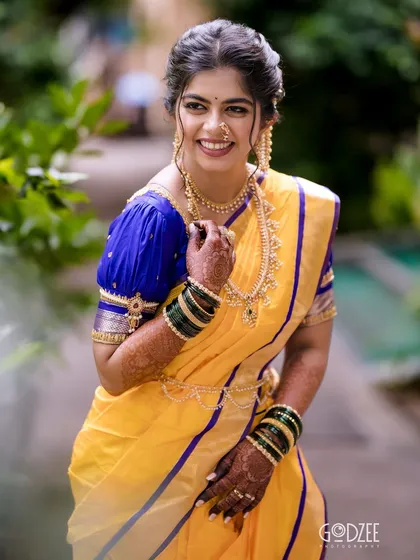 The smile of a happy bride says it all. Her natural makeup look perfectly complements her traditional Maharashtrian attire.