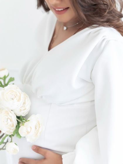A close-up detail shot focusing on the baby bump and delicate flowers. We focus on capturing all the small, beautiful details that tell the story of your pregnancy journey.