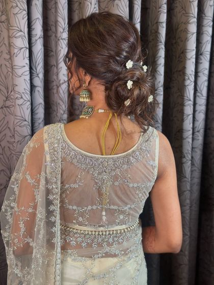 A close-up of the messy updo, showing the texture and the delicate placement of the flowers.
