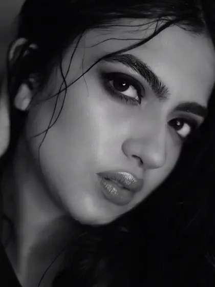 This shot captures the full effect of the wet hair look, with strands artfully placed across the face. The glossy lips and luminous skin complete this edgy, high-fashion aesthetic.