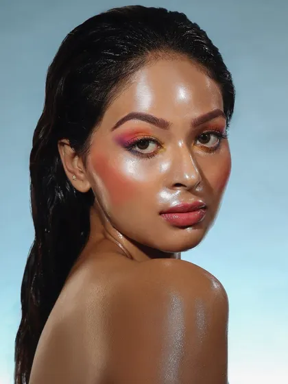 A warm, sunset-inspired glass skin look with a blend of orange and pink. The wet-look hair completes this stunning, high-fashion concept.