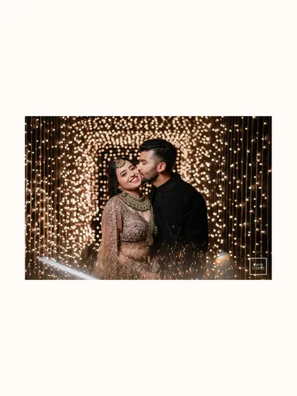 A romantic kiss against a backdrop of sparkling lights. This beautifully lit portrait from a reception is the epitome of romance and celebration.