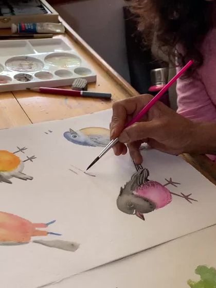 A student practices painting small, colorful birds in watercolor. Nature provides endless inspiration, and our courses help you capture its beauty.