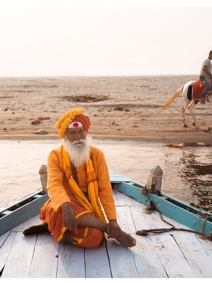 A serene morning in Banaras, with a sadhu meditating on a boat as a horseman passes on the shore. This composition highlights the different worlds that coexist along the river.