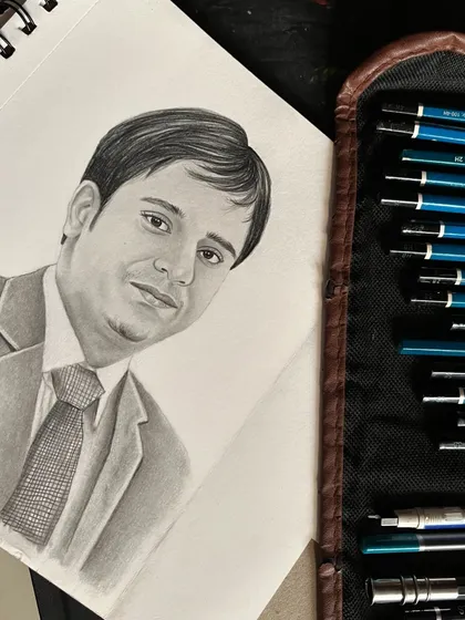 The portrait seen on my sketchbook next to my set of drawing pencils, giving a glimpse into the tools I use for my commissioned artwork.