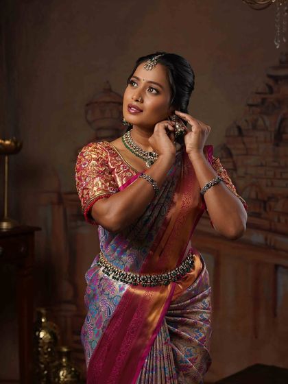 Another beautiful shot of Ramya adjusting her jewelry. My draping ensures that even with movement, the saree's pallu and pleats remain perfectly intact for photos.