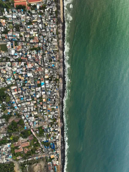 A top-down view of a city slum right next to the sea. This shot offers a powerful commentary on the contrasts of urban life and our relationship with the environment.