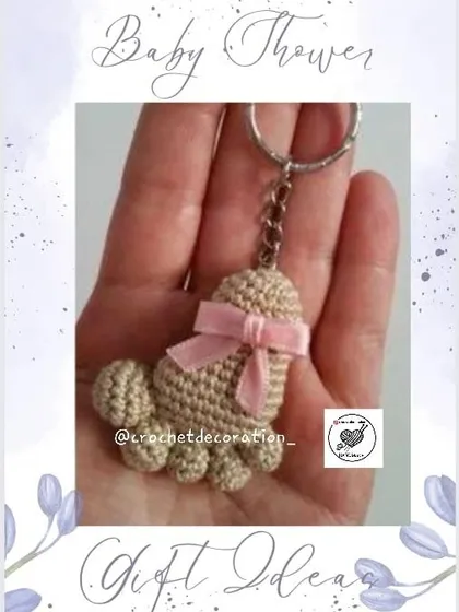 A beautiful baby feet keychain in a neutral color with a pink bow. These are thoughtful and customizable gifts for baby showers, gender reveals, or to welcome a new baby.