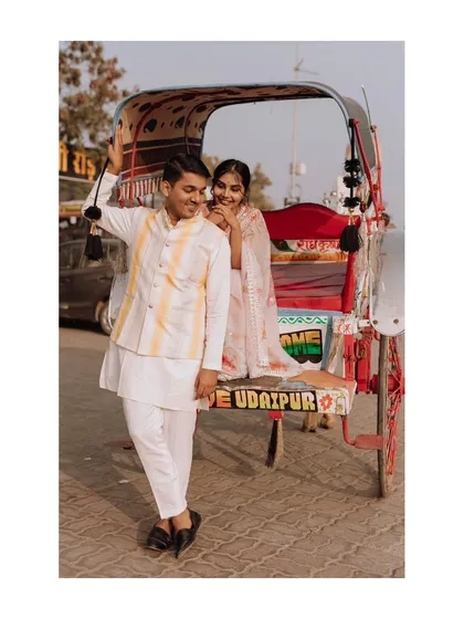A stylish portrait of the couple posing with their decorated rickshaw, blending modern style with traditional Rajasthani elements.
