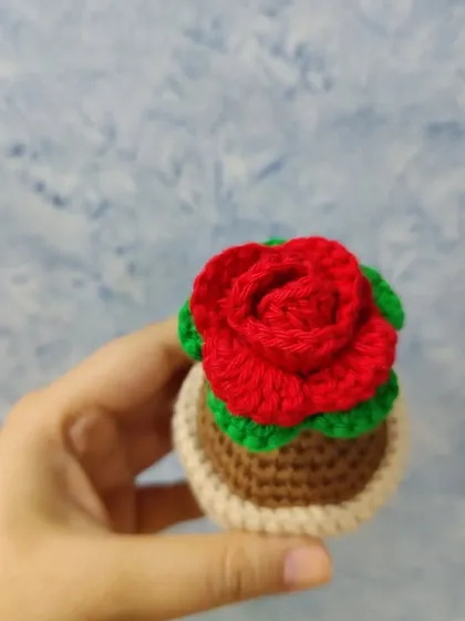 A top-down view of the crochet rose pot, highlighting the detailed petal work of the rose. I take care to make each flower look as realistic and beautiful as possible.