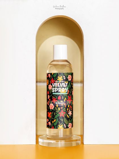 A duplicate of a previous shot, showing the body spray framed in a white arch. This composition is effective for drawing attention directly to the product.