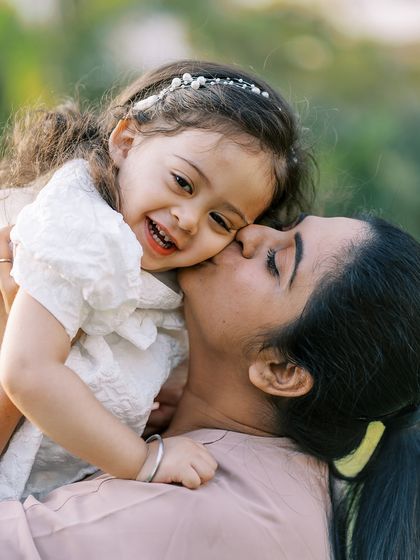 A mother holding her daughter, both sharing a huge smile. The pure joy in this photo is contagious.